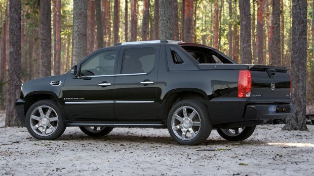 Image de trois quarts arrière gauche d'une camionnette Cadillac Escalade EXT 2009 dans une forêt