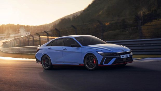 Hyundai i30 Sedan N 2024 facelift sur piste conduisant une voiture bleue