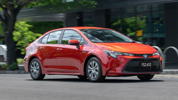 Photo de conduite de la Toyota Corolla Ascent Sport hybride orange 2020