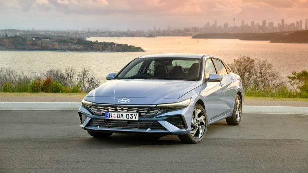 Angle avant de la Hyundai i30 Berline Premium 2024 avec Sydney en arrière-plan
