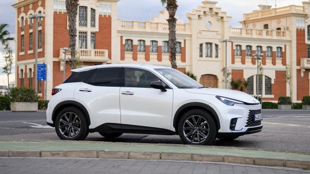 Voiture blanche à angle latéral Lexus LBX 2024 devant un bâtiment