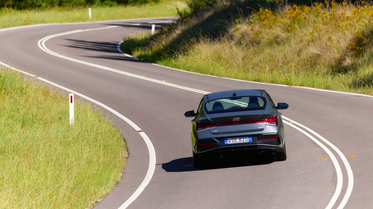 Hyundai i30 Berline hybride 2024 conduite arrière loin